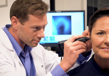 Male clinician performing video otoscopy in female client.