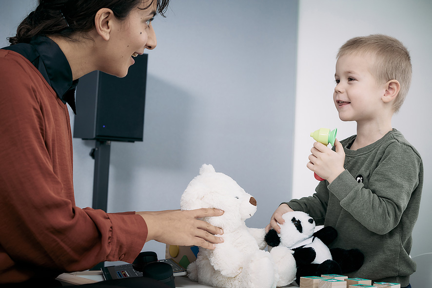 Clinician and patient playing with a few toys and teddys, with the Touch Keyboard and Ling-6 blocks at the ready to start play audiometry testing immediately once the child is ready.